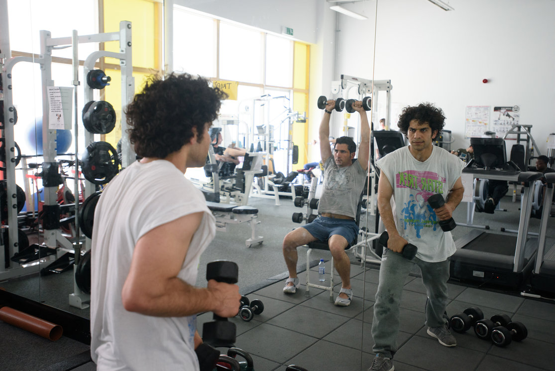 Community class man in gym class with weights gallery