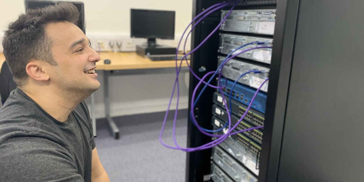 student working at a bank of computer data servers