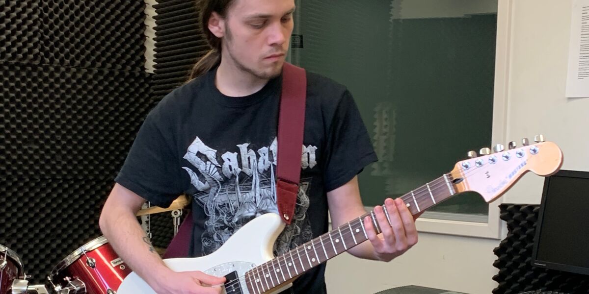 Music student playing the electric guitar in sound studio