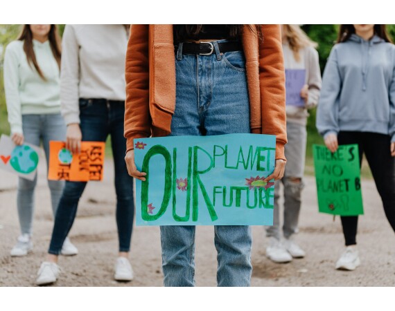 Image of someone with banner saying 'Our Planet, Our future'.