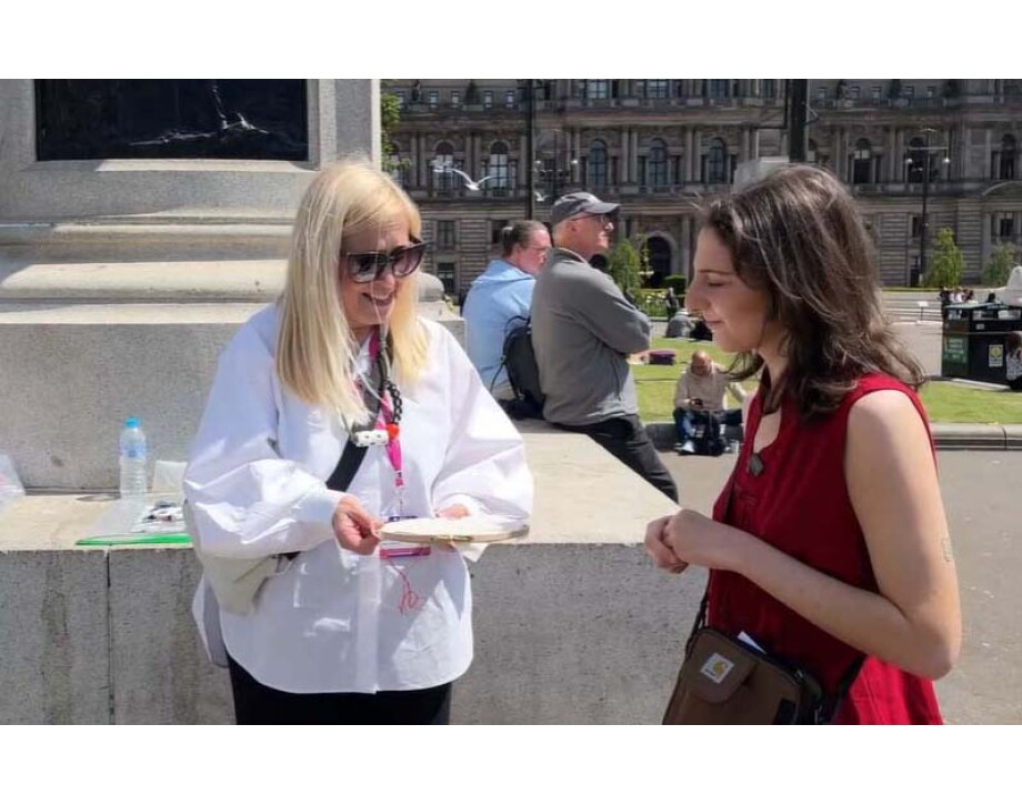 Image shows lecturer demonstrating embroidery technique to a lady in George Square.