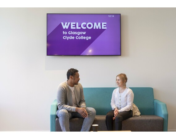 Welcome to Glasgow Clyde College Anniesland Campus male and female student talking on seats