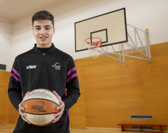 male sports student holding a basketball