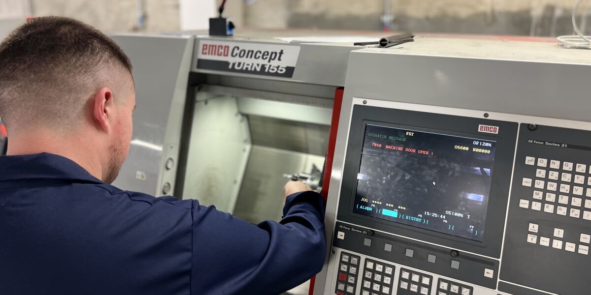 Male student working with manufacturing equipment