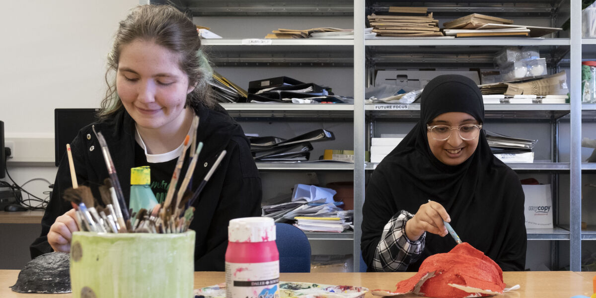 Three students undertaking an art project.