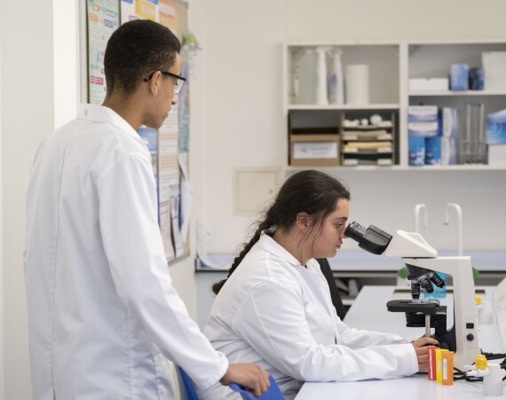 Two students using a microscope