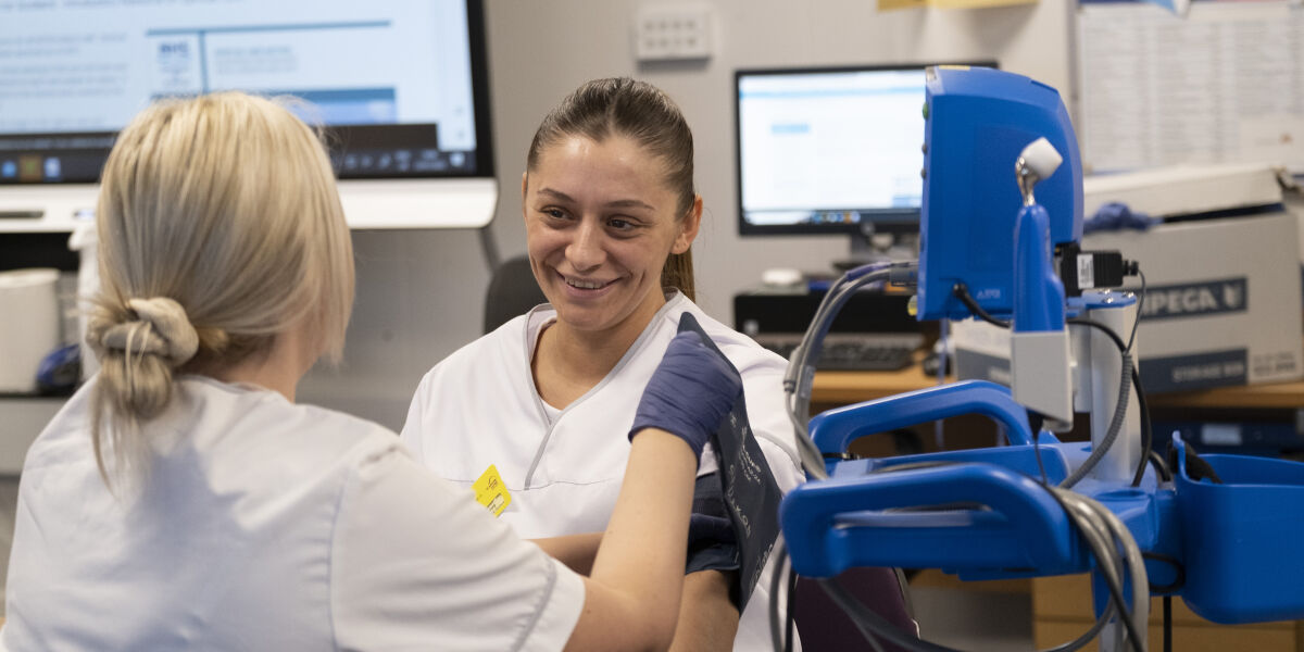 Healthcare students using a blood pressure monitor