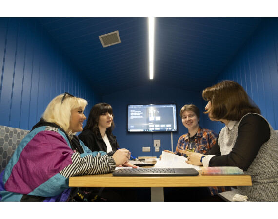Four students sitting studying around a table