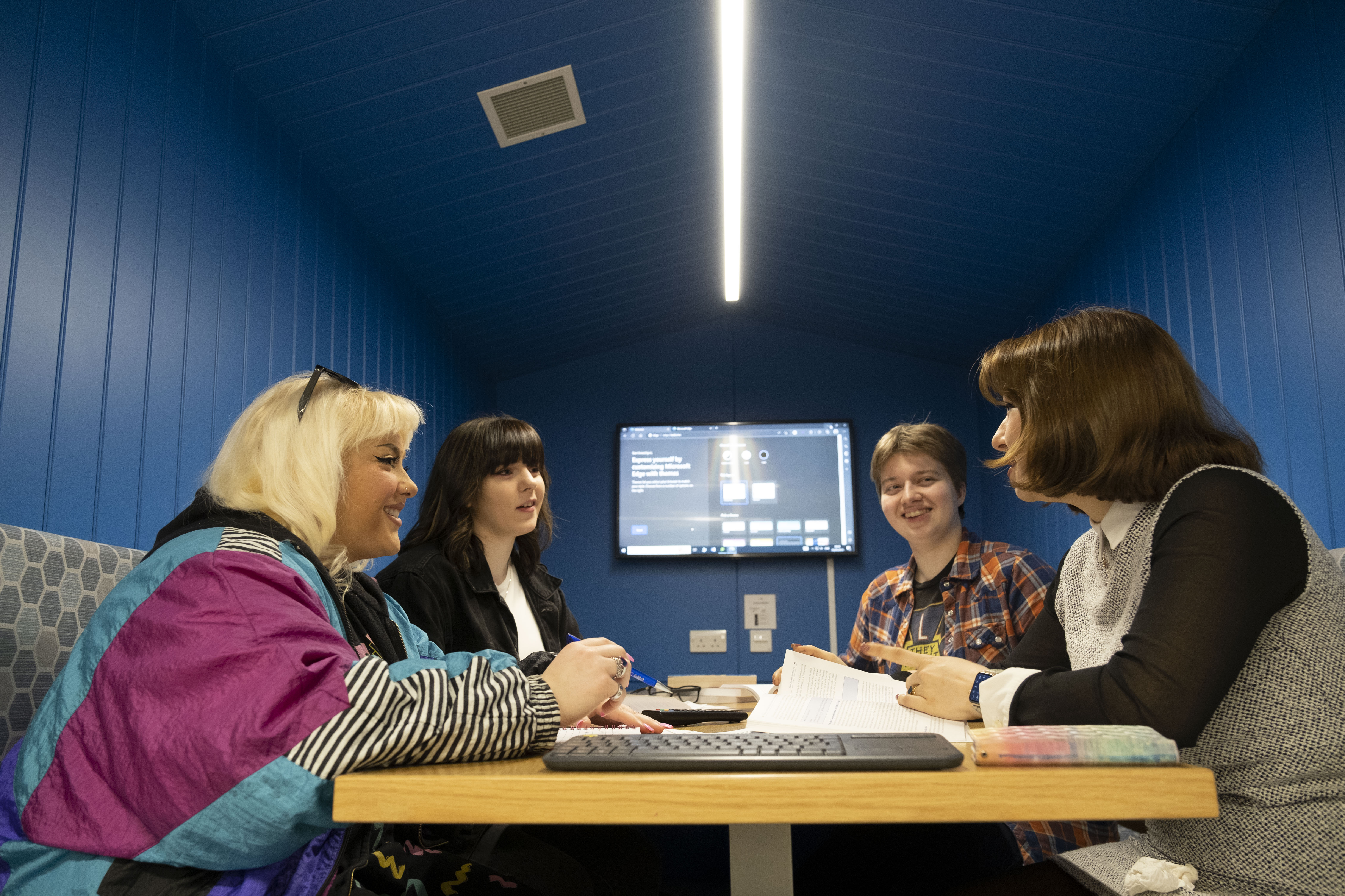 Four students sitting studying around a table