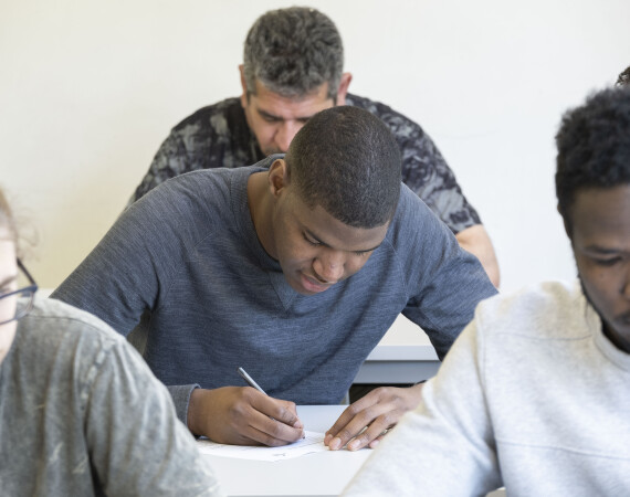 A group of male students taking notes at their desks