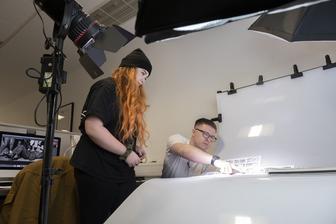 Graphic design students setting up product photography gallery