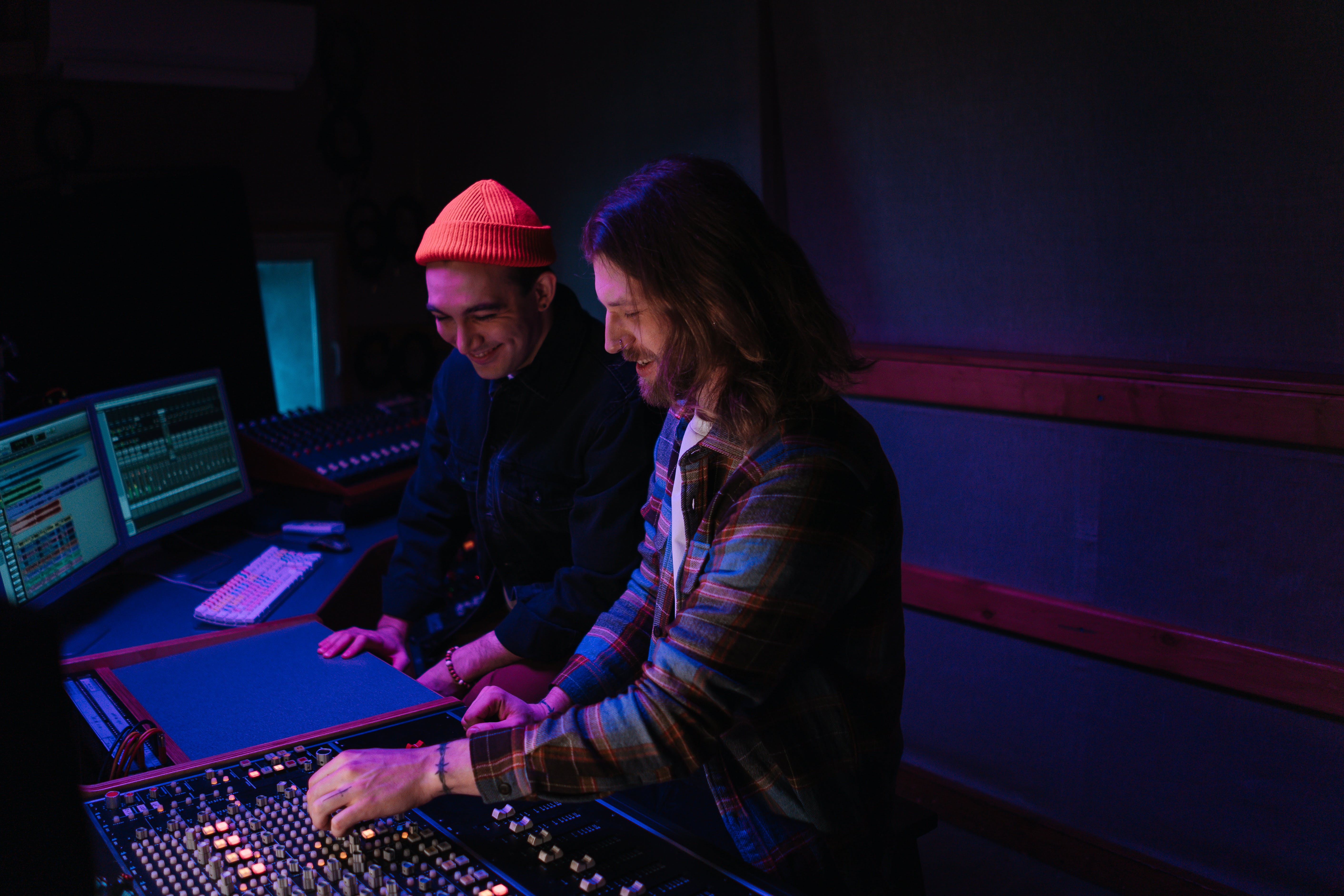 Close up of 2 males working in sound studio