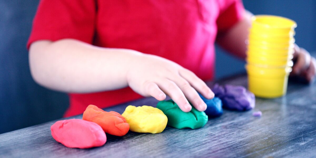 A child playing with different coloured modelling clays.