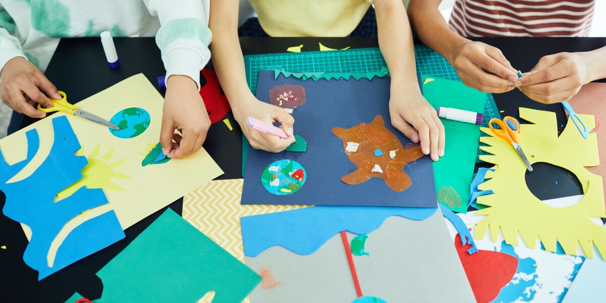 Children doing arts and crafts with different coloured papers.