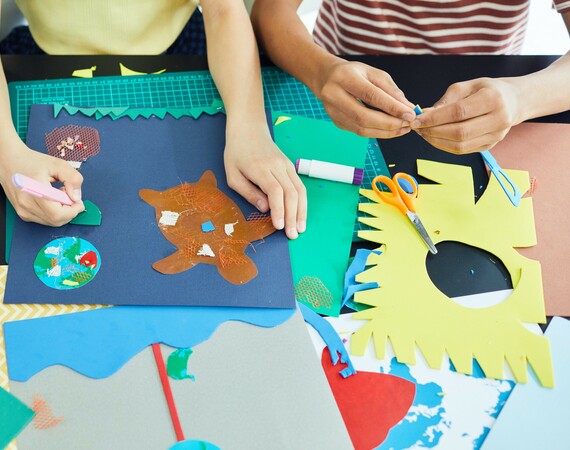 Children doing arts and crafts with different coloured papers.