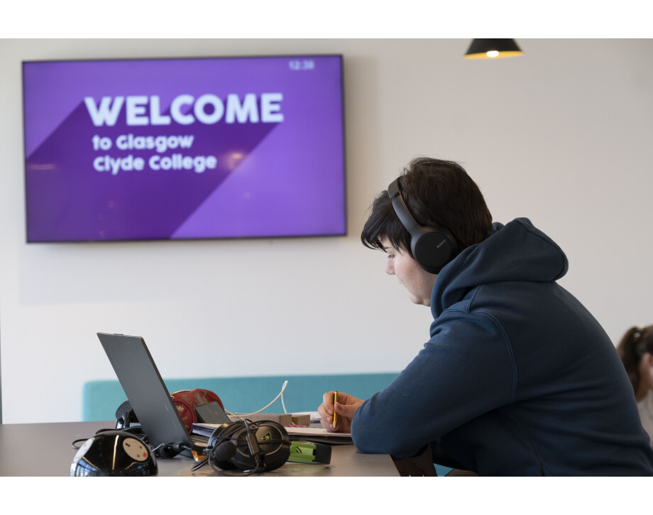 Student wearing headphones using a laptop.