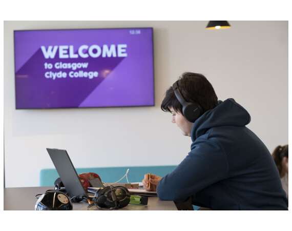 Student wearing headphones using a laptop.