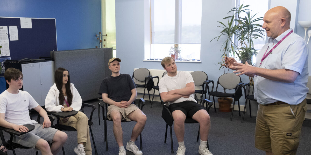 A group of students sitting in a half circle listening