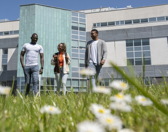 Two male and a female student walking outside