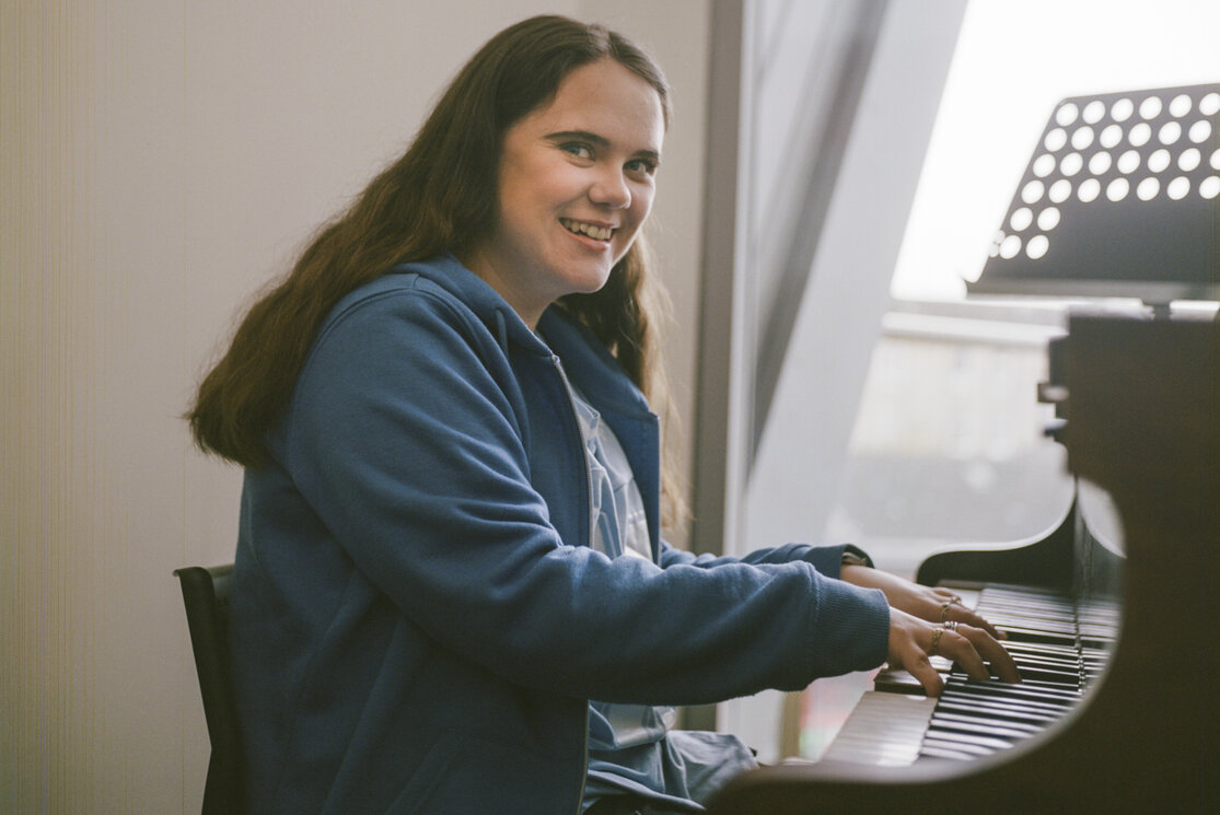 Student playing piano in music studio gallery