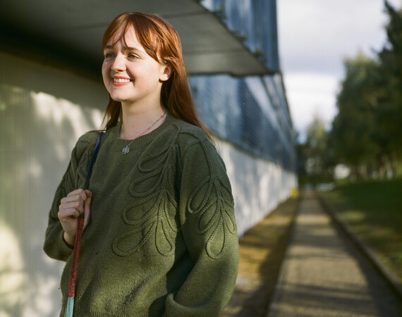 Girl looking to the left wearing a green jumper. 