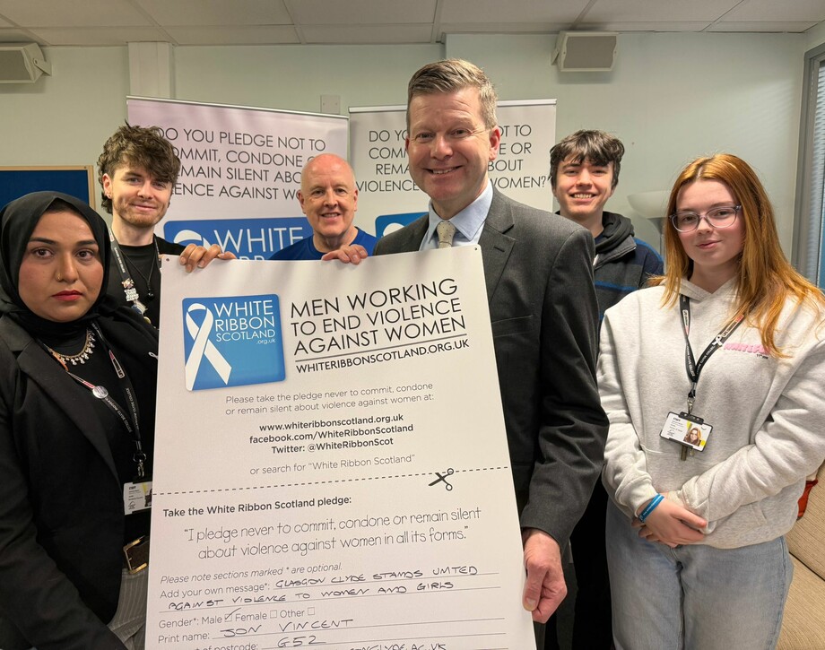 Image show principal Jon Vincent with Davy Thomson from White Ribbon Scotland and members of the Student Association