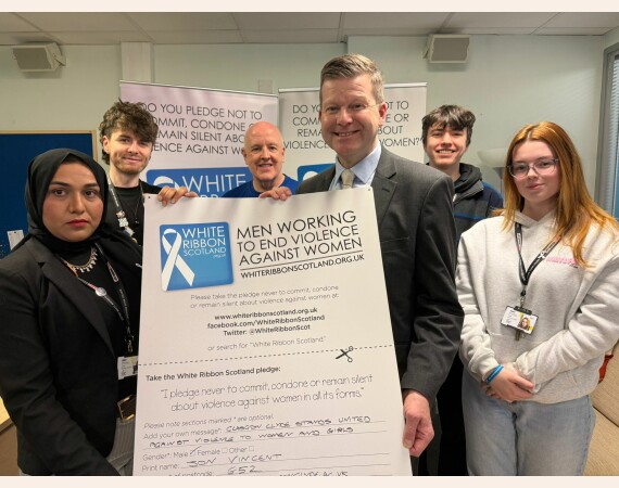 Image show principal Jon Vincent with Davy Thomson from White Ribbon Scotland and members of the Student Association
