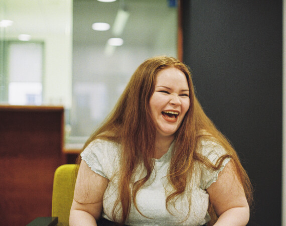 Female student laughing in seating area