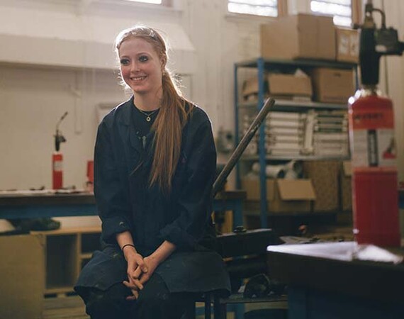 Female plumbing student sitting in workshop