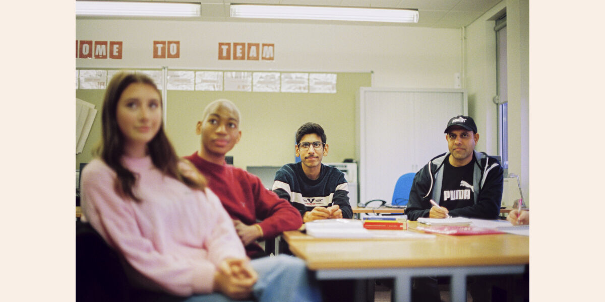 Mixed group of students listening in classroom