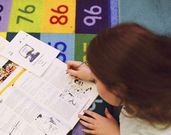 Childcare student working on floor of childcare classroom