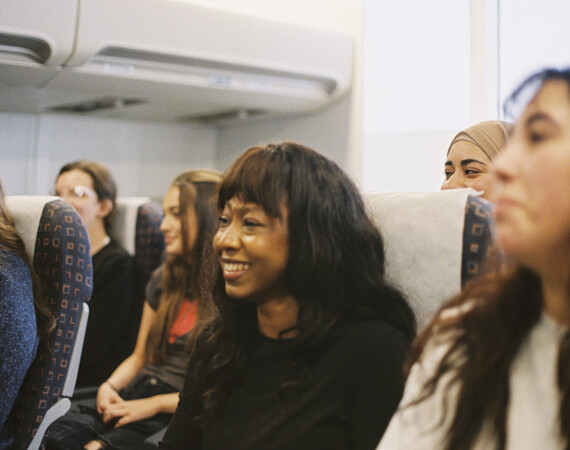 Travel students seated in mock aircraft cabin.