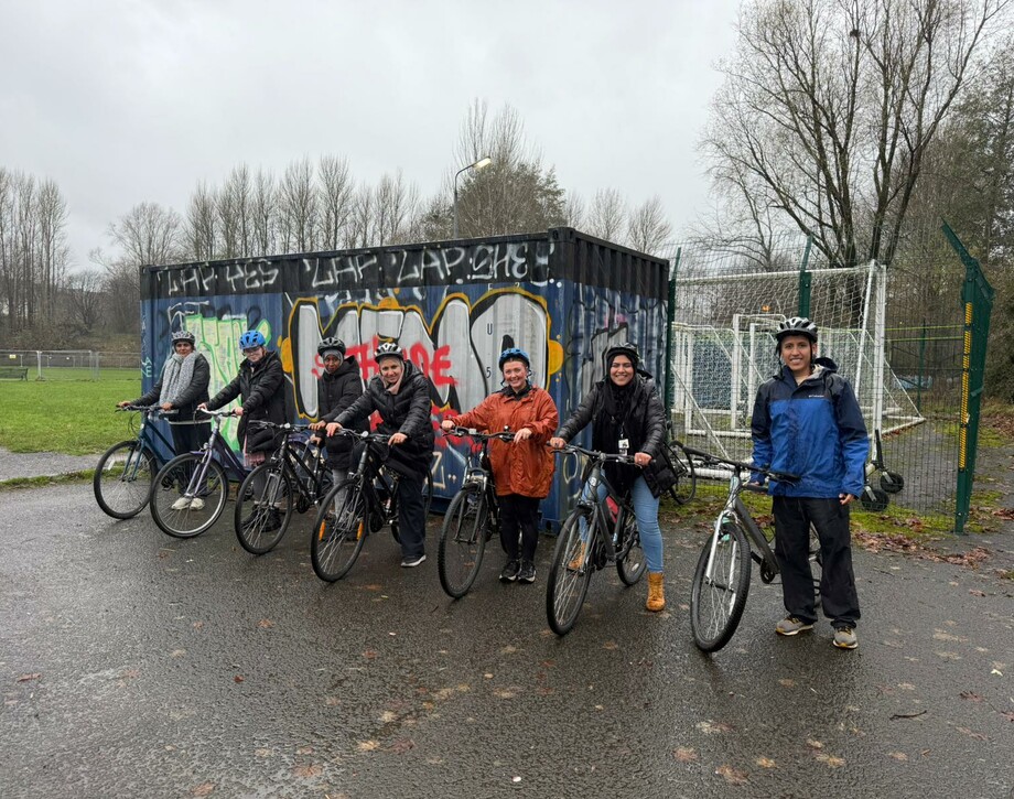 Image shows a group of students on bikes with the cycling campus officer.
